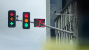 Linnaliikluse foor pimedas õhtus, mis on töökorras ja põleb värviliselt.