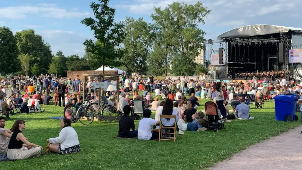 Inimesed naudivad vabaõhukontserti suvisel muruplatsil Tartu sümfooniaorkestri esituses.