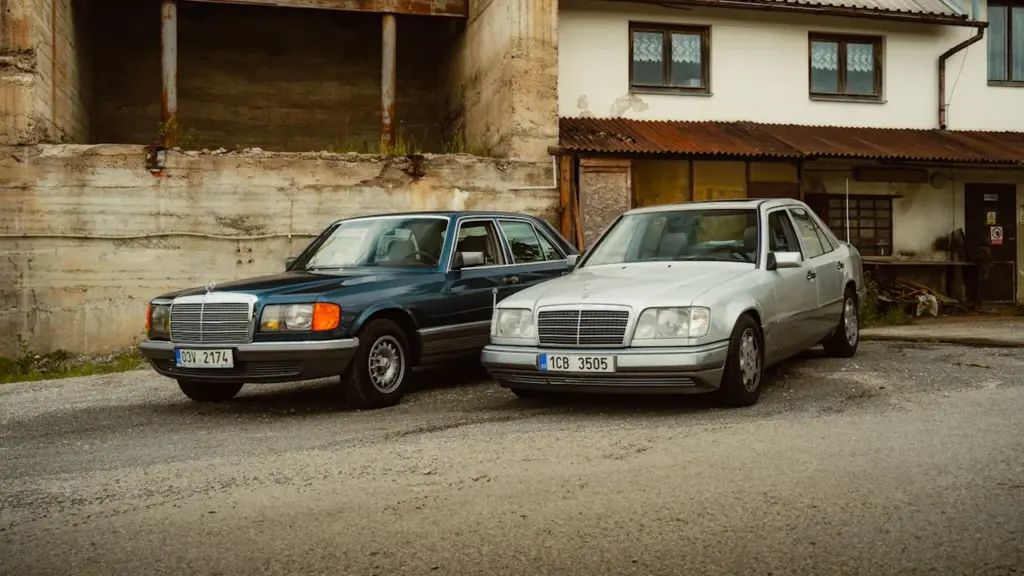 Kaks klassikalist Mercedes-Benzi autot pargitud maapiirkonna hoone ette Põlvamaa sündmuse tähistamiseks.